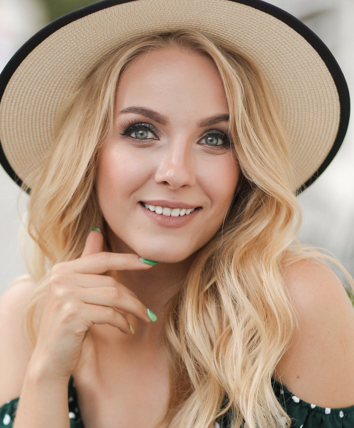 Smiling woman in a stylish hat outdoors.