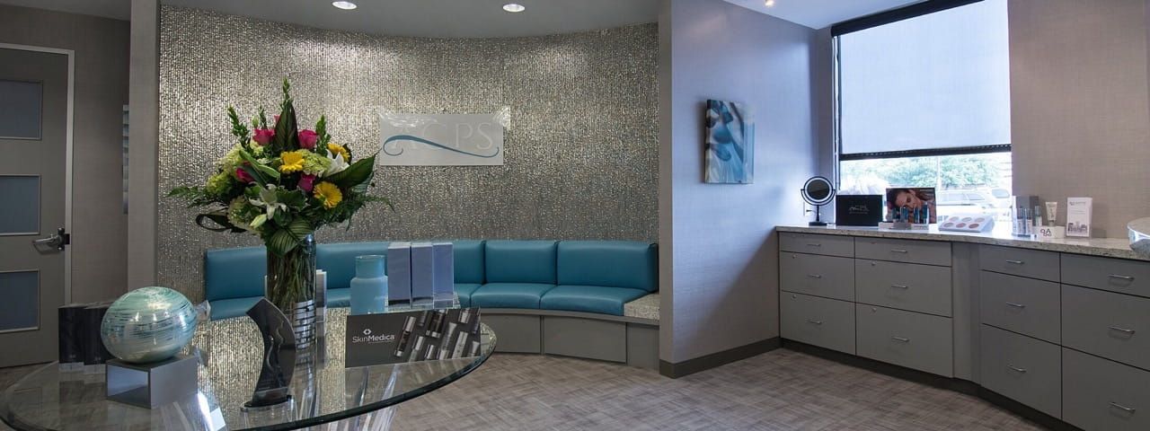Modern reception area with blue seating and flowers.