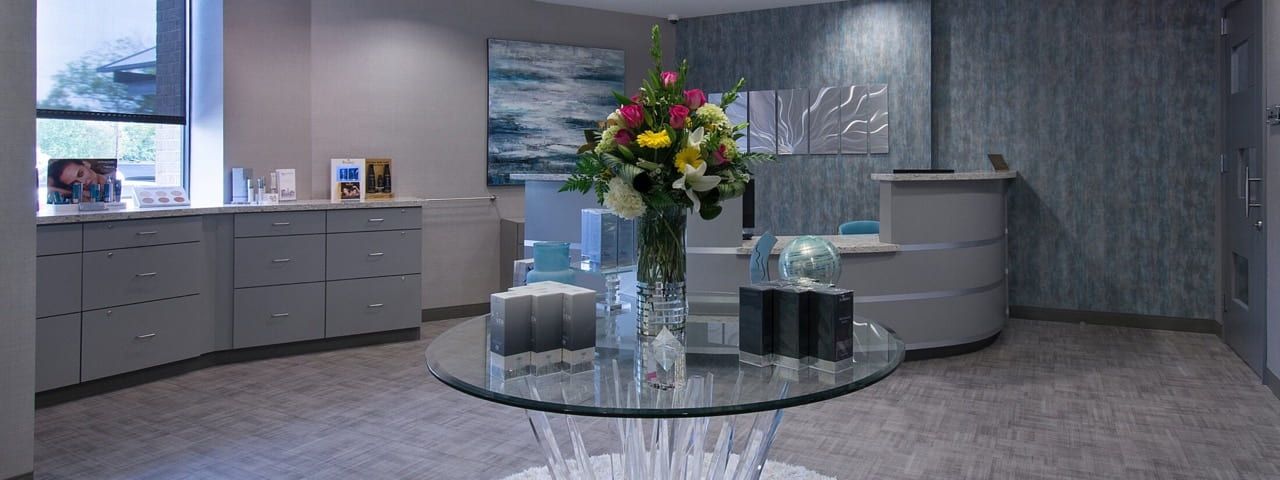 Modern reception area with flowers and products.