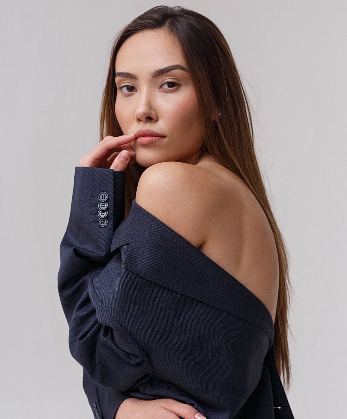 Woman in oversized blazer, elegant pose.