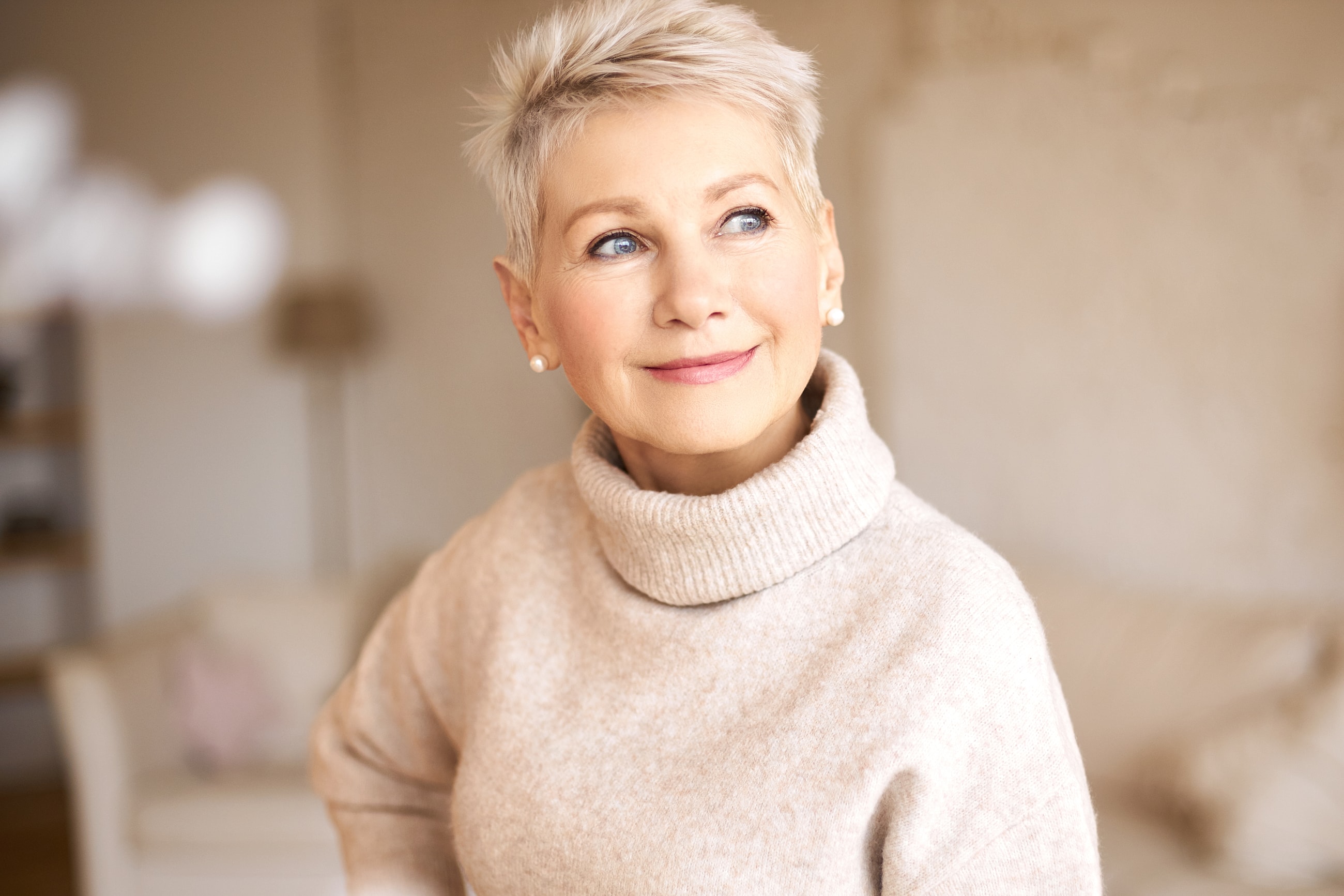Smiling woman in cozy sweater indoors.