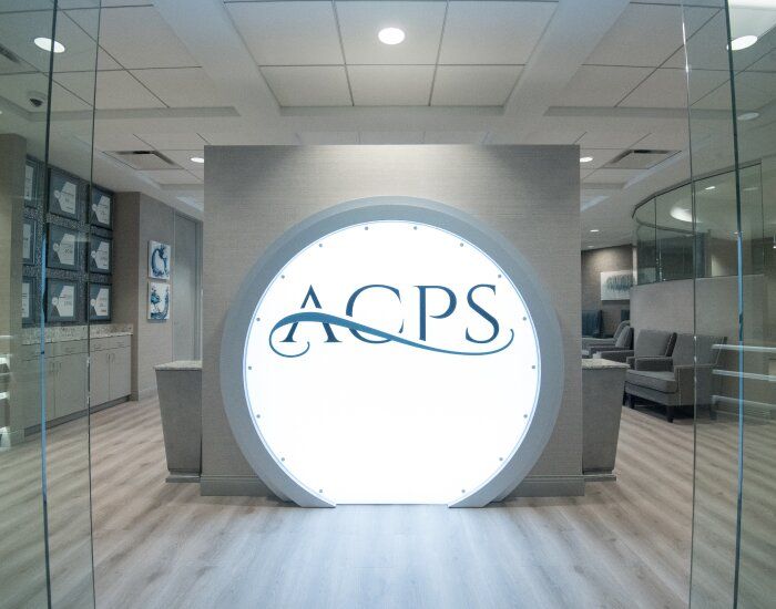 ACPS logo in a modern interior setting.