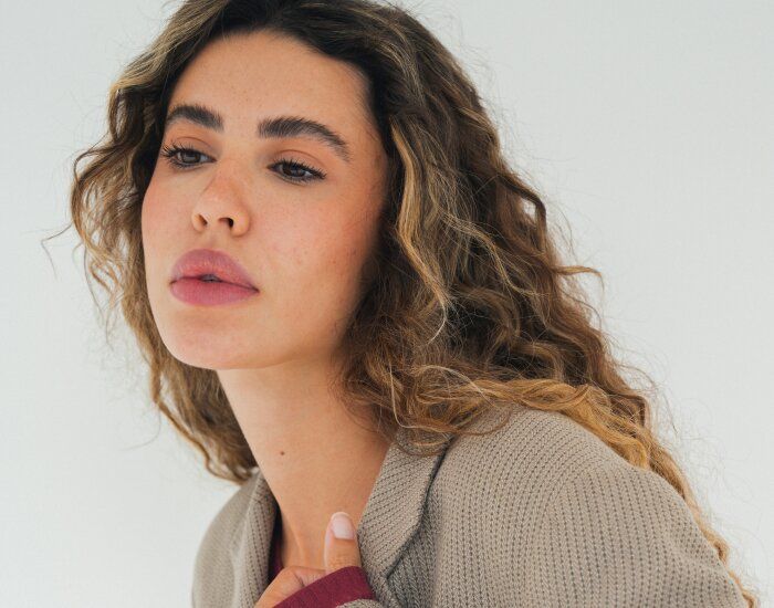 Woman with curly hair in neutral attire.