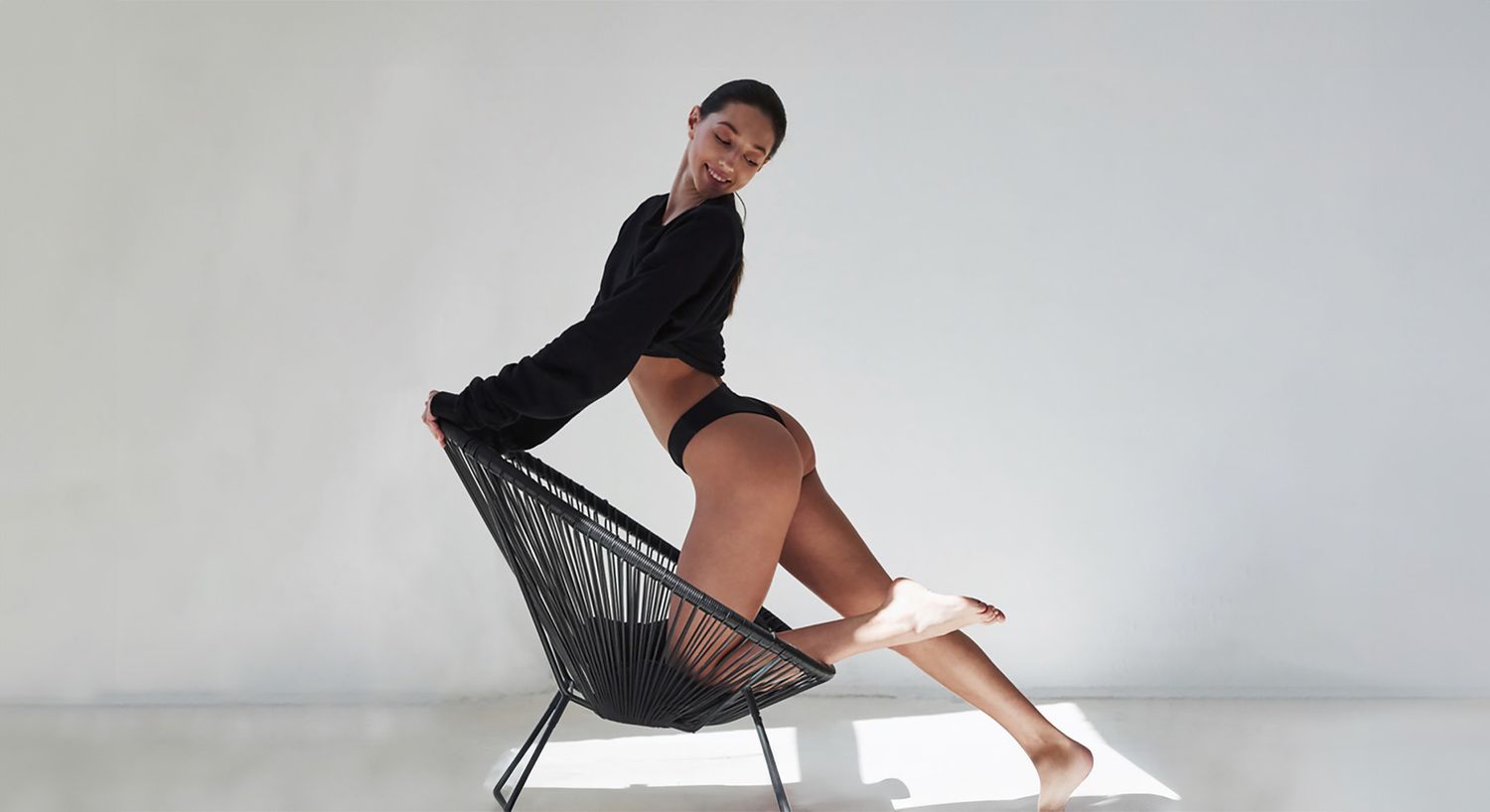 Woman posing playfully on a chair.