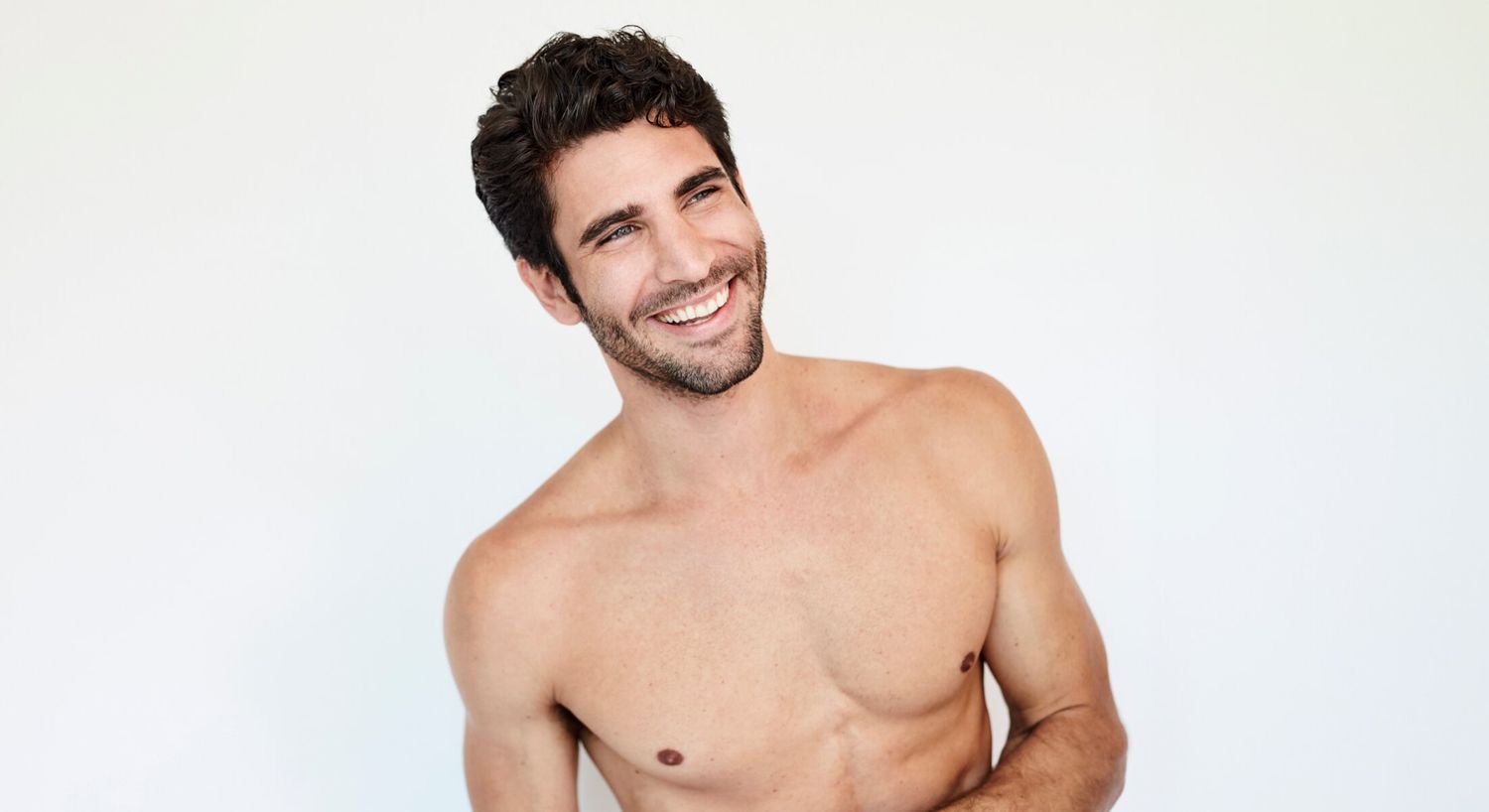 Smiling man with short dark hair shirtless.
